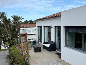 a patio of a house with a chair and a window at Casa Caloura Natura Deluxe Accommodation & Spa in Caloura