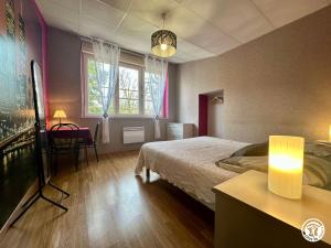 a bedroom with a bed and a desk and a table sidx sidx sidx at La Maison du Parc in Les Maillys