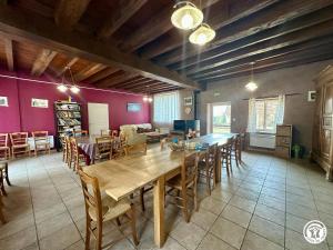 a dining room with a large wooden table and chairs at La Maison du Parc in Les Maillys