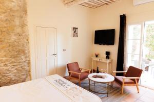 a bedroom with a bed and a table and chairs at Château Catherine de Montgolfier - B&B et Gites - Piscine - Domaine viticole bio avec dégustation in Narbonne