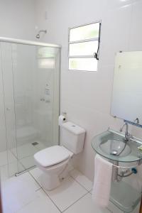 uma casa de banho com um WC, um lavatório e um chuveiro em Acalanto Inn em Socorro