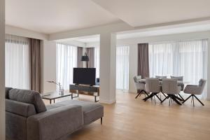 a living room with a couch and a table and chairs at September Athens Residences in Athens