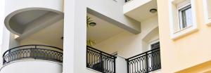 a white building with a balcony with plants on it at SUMMER Home in Agios Nikolaos +72 photos