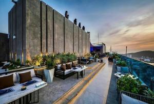a rooftop patio with couches and plants on a building at Khách sạn San Hô Vũng Tàu (Coral Hotel) in Vung Tau