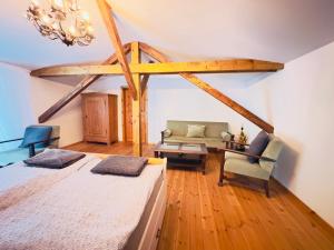 a bedroom with a bed and a couch and a chandelier at Privates Ferienhaus mit großem Garten in Rauen