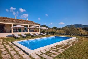a villa with a swimming pool in front of a house at Finca Son Cladera in Sa Pobla