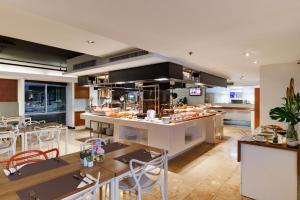 a restaurant with a kitchen with tables and chairs at S15 Sukhumvit Hotel in Bangkok
