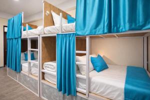 a bunk bed room with two bunk beds with blue curtains at FUNKY MONKEY- A Hostel, Hotel and Apartment in Kathmandu +26 photos