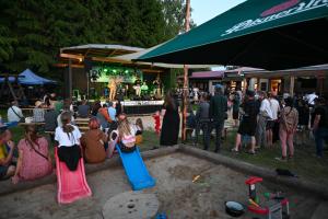 a group of people sitting in the sand at a party at Kemp Karvánky in Dráchov