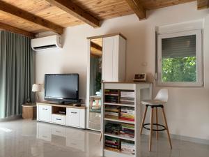 a living room with a television and a stool at Ostrog Retreat in Donja Povija