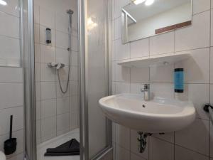 a white bathroom with a sink and a shower at STEP IN Apartments ! in Wilhelmshaven +44 photos