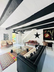 a living room with a black couch and a glass table at Maison Quercus in Vaylats