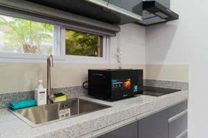 a kitchen counter with a microwave and a sink at Philla D Afrique Resort in Inopacan