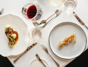 a white table with plates of food and a glass of wine at Farmhouse Milla Montis in Maranza