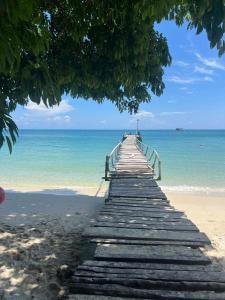 a wooden pier stretches out over the beach at Benny beach house in Ko Samed