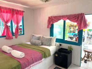 a bedroom with two beds with red curtains and a window at Benny beach house in Ko Samed