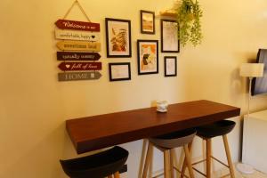 a table and stools in a room with signs on the wall at Balay Buenavista in Magdalena