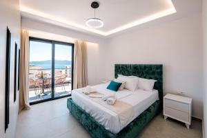 a bedroom with a large bed and a balcony at Seaview Deda 02 in Sarandë