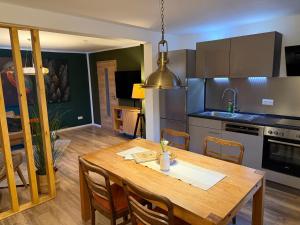 a kitchen with a wooden table and a dining room at Harzhaus Ida in Elbingerode