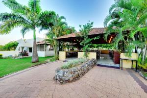 a house with palm trees in front of it at Royal Garden Brindavan Resort in Hosa Kannambādi