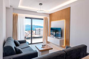 a living room with a couch and a large window at Seaview Deda 02 in Sarandë