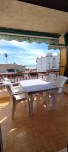 a white table and chairs on a balcony at Apartamento en la playa in Cunit +4 photos