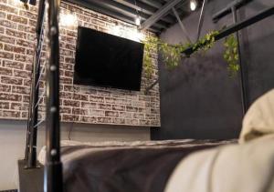 a room with a brick wall with a tv on it at Rivers Edge Lofts - Unit 5 in Niles