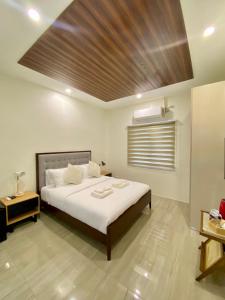 a bedroom with a large bed with a wooden ceiling at Philla D Afrique Resort in Inopacan +32 photos