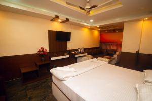 a bedroom with a large white bed and a kitchen at D. K. INTERNATIONAL HOTEL PVT. LTD in Calcutta Bara Bazar
