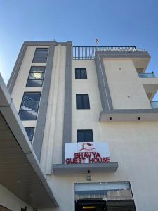a building with a sign on the side of it at Bhavya Guest House in Rīngas