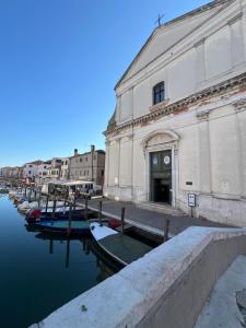a building with boats in the water next to a canal at Casa PIVA 781 in Chioggia