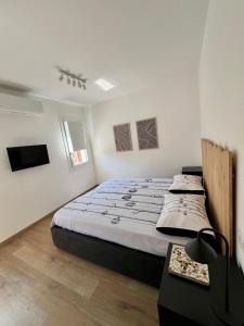 a bedroom with a large bed and a tv at Casa PIVA 781 in Chioggia
