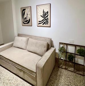 a couch in a room with three pictures on the wall at Casa PIVA 781 in Chioggia