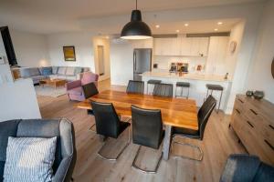 a kitchen and living room with a wooden table and chairs at Luxury Condo with Stunning View and Pool in Baie-Saint-Paul