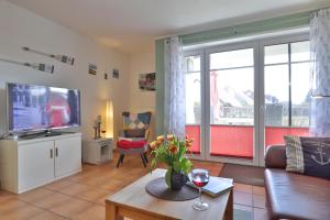 a living room with a couch and a tv at 2 Zimmer Appartement Poseidon in Boltenhagen