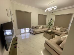 a living room with couches and a flat screen tv at Sohag luxury apartment in Awlād Gharīb