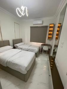 a hotel room with two beds and a projection screen at Sohag luxury apartment in Awlād Gharīb