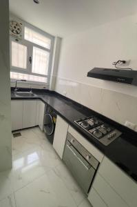a kitchen with a sink and a stove top oven at Sohag luxury apartment in Awlād Gharīb