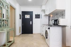 a kitchen with a washing machine and a black door at LuxSevilla Apartment Piscina in Bormujos