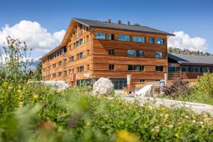 a large wooden building in front of a building at SWISSPEAK Resorts by Pierre & Vacances Premium Vercorin in Vercorin
