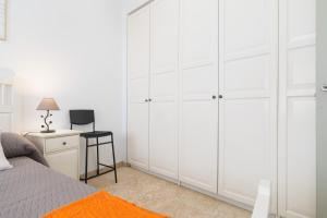 a bedroom with white cabinets and a desk at LuxSevilla Apartment Piscina in Bormujos