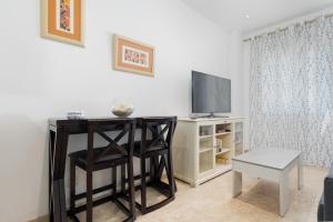 a living room with a table and a television at LuxSevilla Apartment Piscina in Bormujos