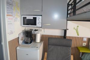 a small kitchen with a microwave and a refrigerator at la PASSERONNE in Barbentane