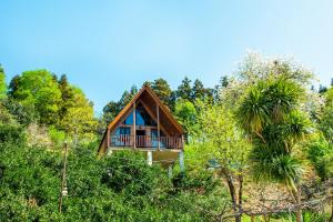 a house with a balcony in the middle of trees at Veranda Buknari in Buknari
