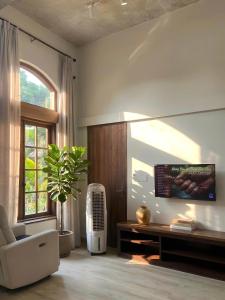 a living room with a couch and a tv and a window at Sum Homestay Hue - Gần cầu Nguyễn Hoàng in Hue