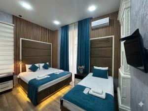 a hotel room with two beds and a television at Baku City Inn Boutique Nizami Hotel in Baku