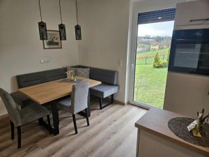 a dining room with a table and chairs and a window at Ferienwohnung 2 am Gleichenberger "Kogl" in Bad Gleichenberg +5 photos