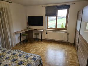 a bedroom with a bed and a desk and a television at Ferienwohnung 2 am Gleichenberger "Kogl" in Bad Gleichenberg