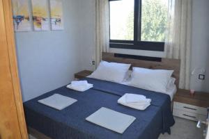 a bedroom with a bed with towels on it at Arethousa House in Nea Vrasna