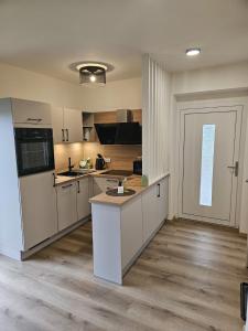 a large kitchen with white cabinets and a door at Ferienwohnung 2 am Gleichenberger "Kogl" in Bad Gleichenberg